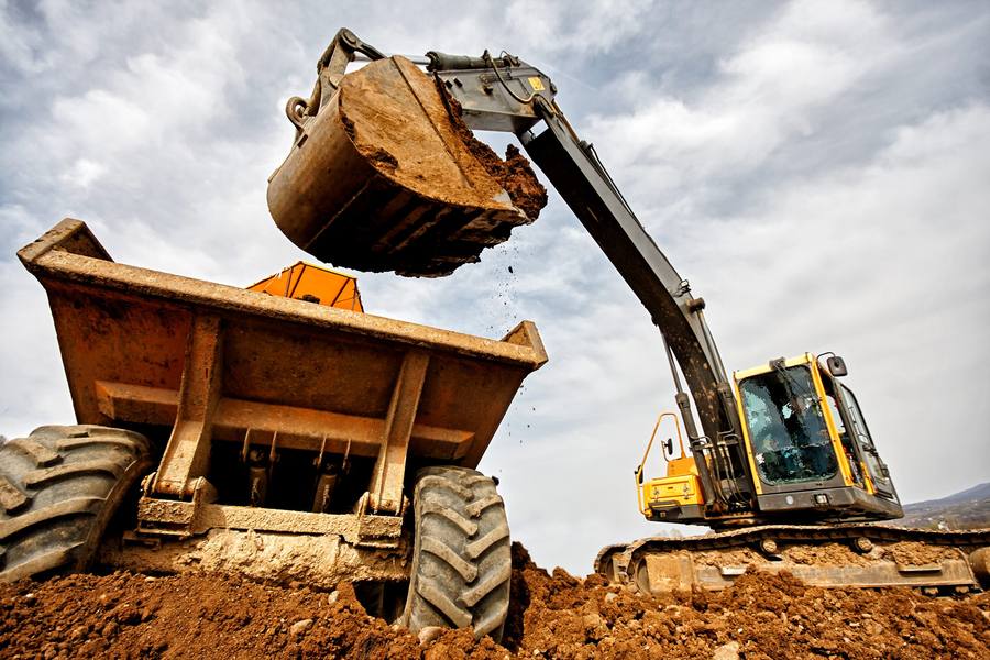Excavator loading spoil into an articulated dumper