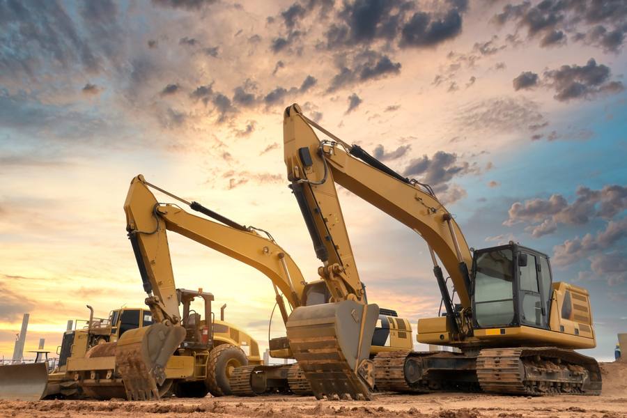Line-up of excavators and construction plant at sunset